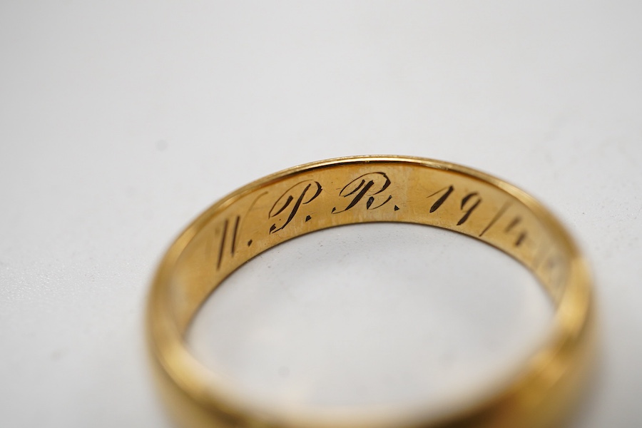 A Far Eastern yellow metal wedding band with engraved inscription, stamped '20', size O, 5 grams.
